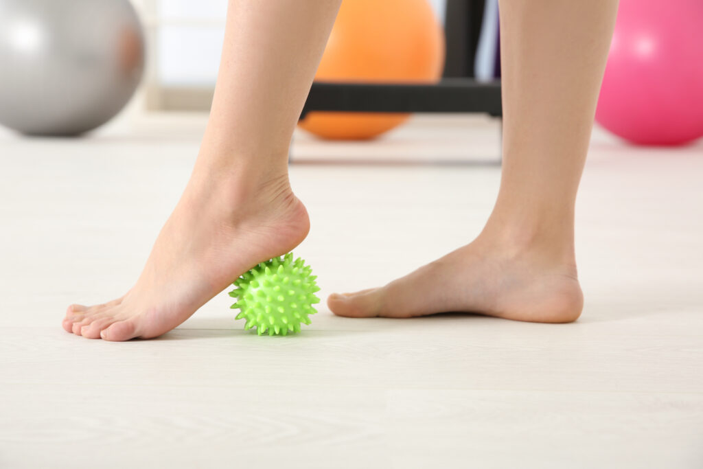 Feet of woman doing exercises with stress ball in clinic