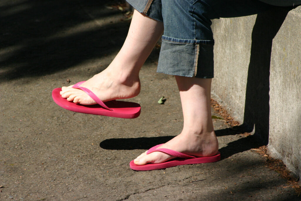 Woman wearing red flip-flops